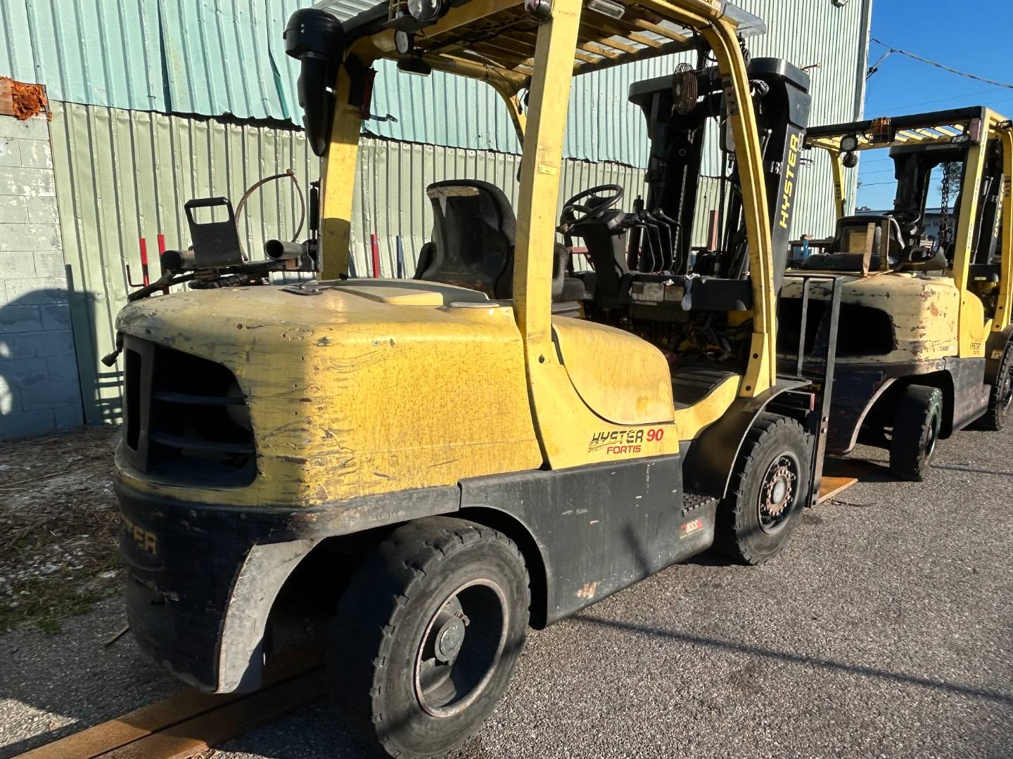 Yellow Hyster forklifts lined up outside a warehouse