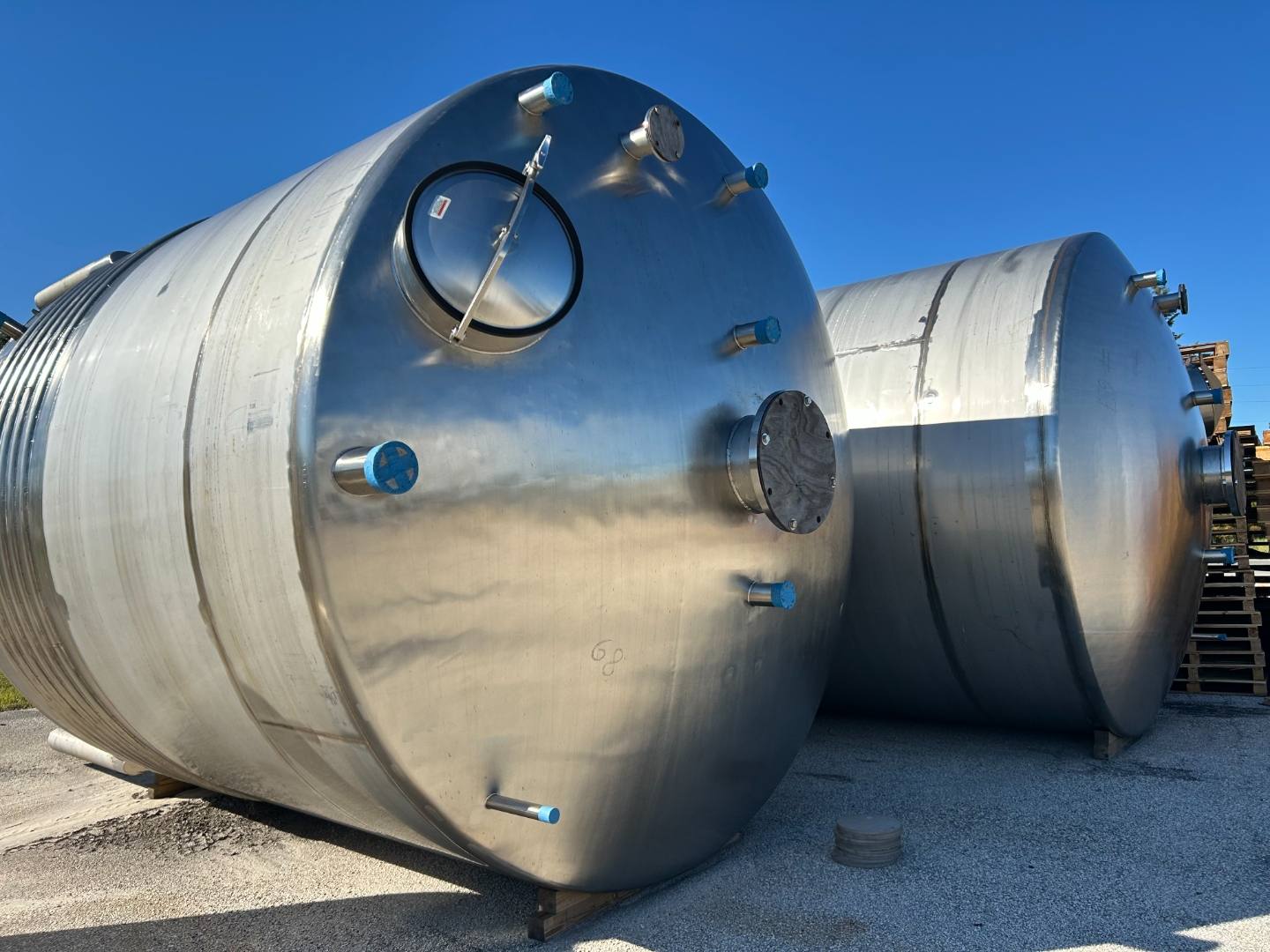 Two large stainless steel tanks in a yard