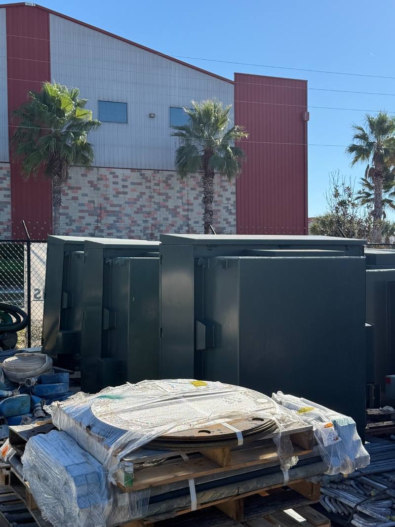 Pad-mount transformers staged on a pallet in an equipment yard