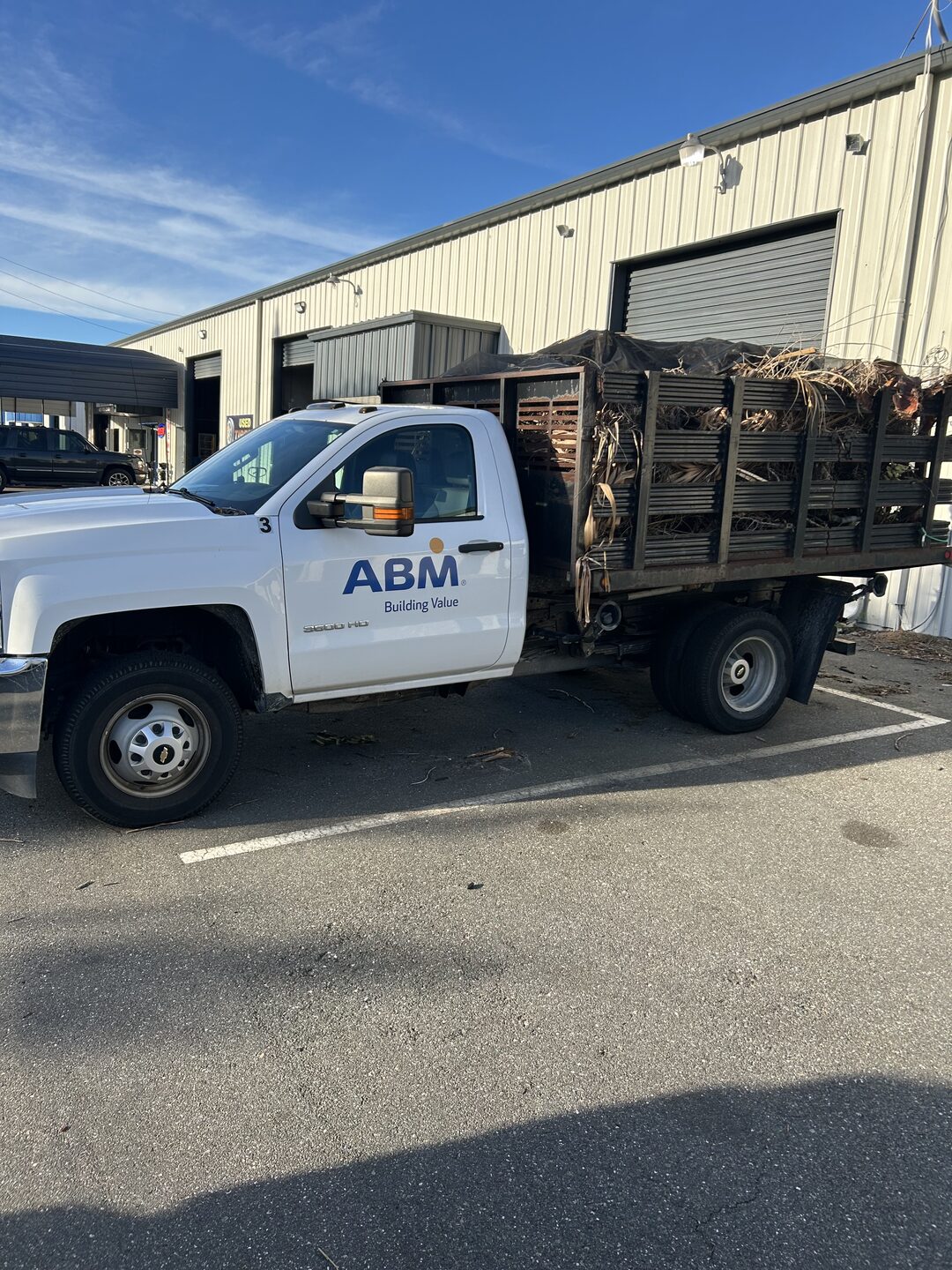 White stake-bed work truck of the kind sold as contractor surplus in Central Florida